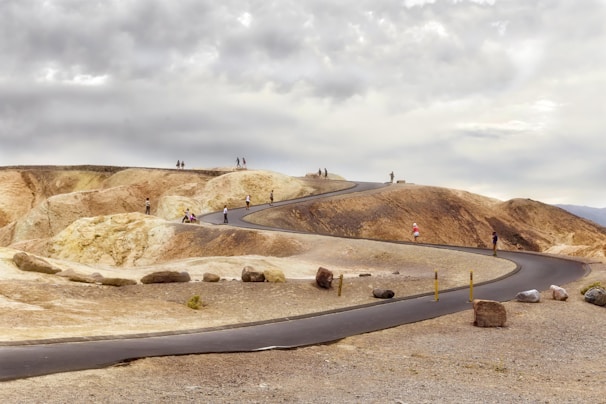 Visitors walking through the barren yet striking landscape of Death Valley during a sunny day.