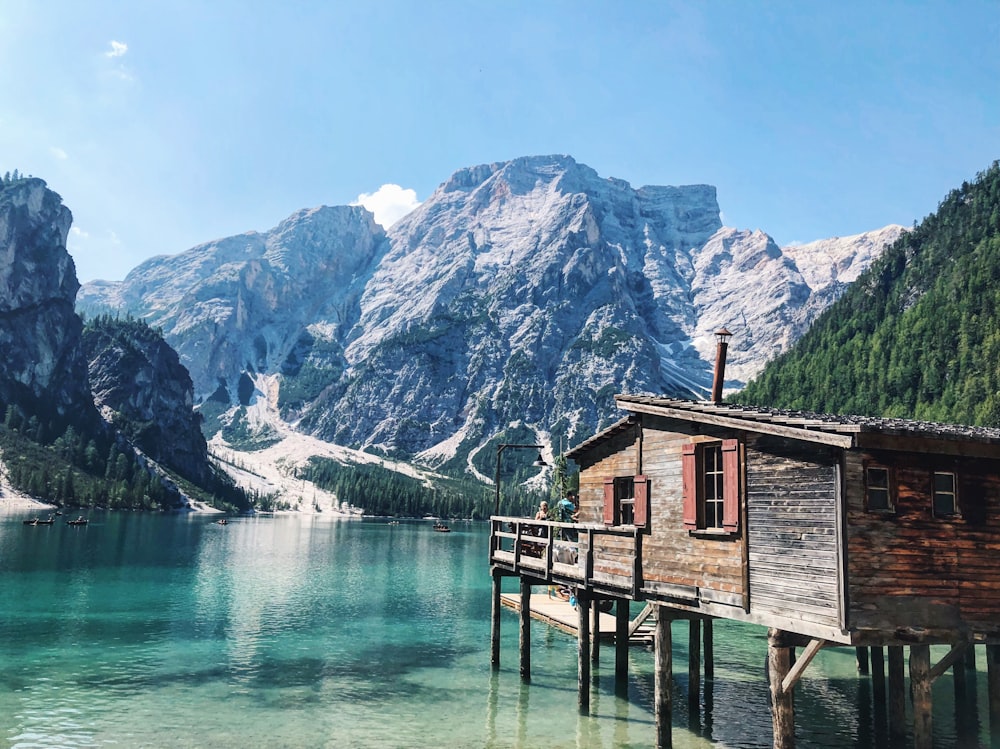 Maison en bois au-dessus d’un plan d’eau près de la montagne