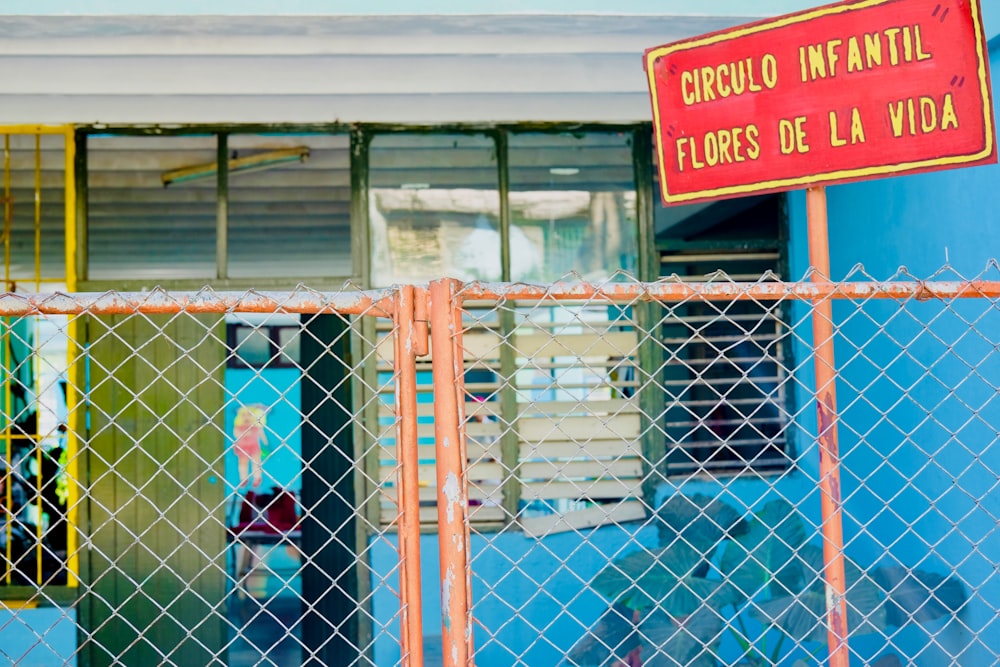 orange and gray fence beside blue concrete building