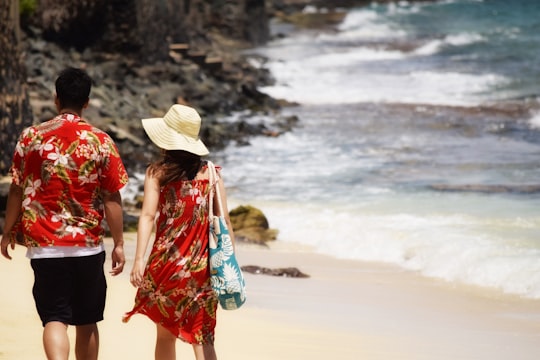 man and woman walking on seashore during daytime in Hawaii County United States