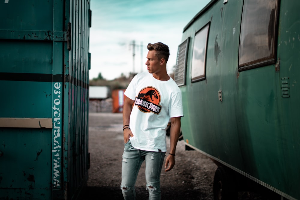 man standing near green metal container