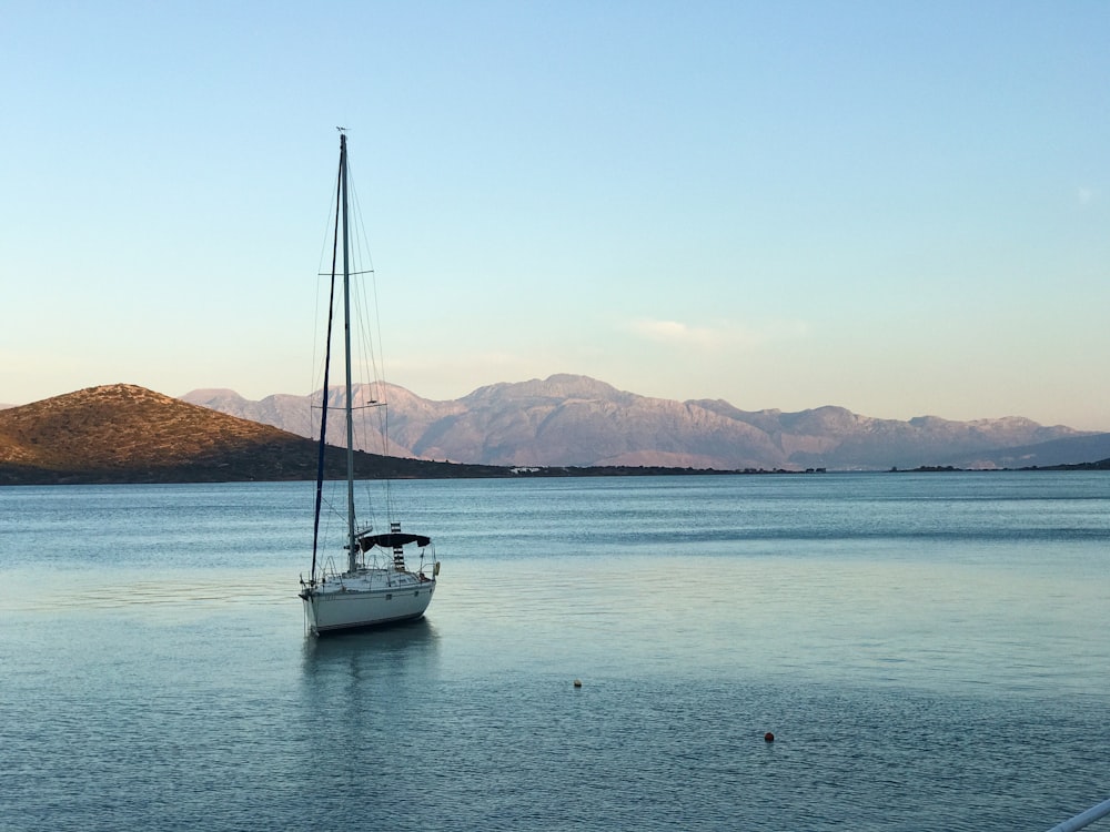 white boat sailing under blue sky during daytime