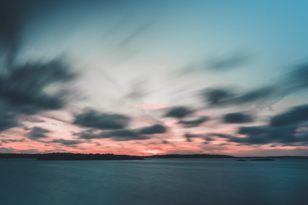 body of water under cloudy sky