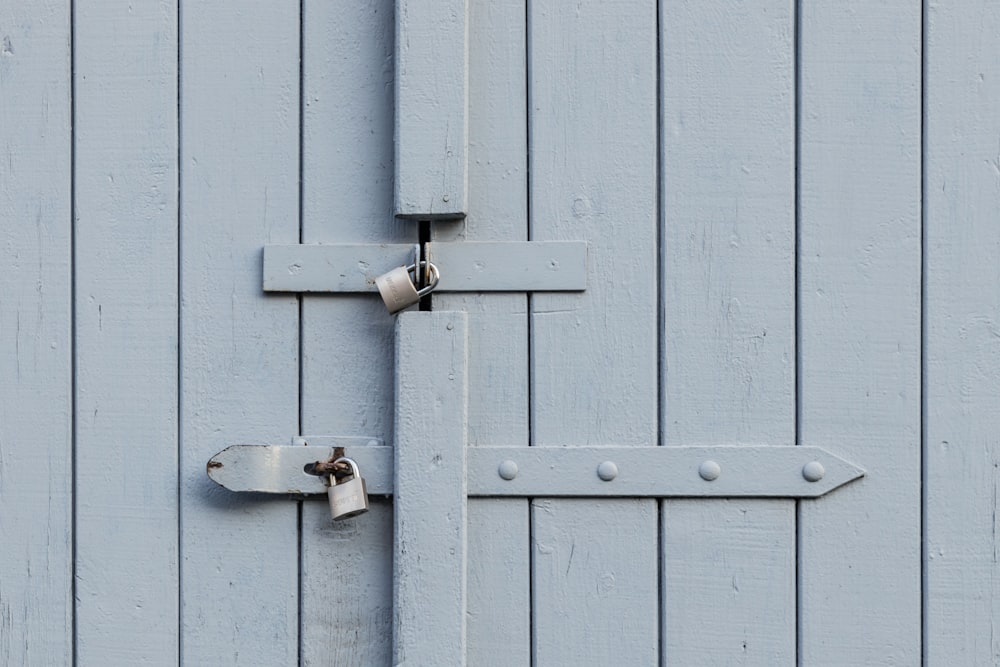 two gray metal padlocks on door