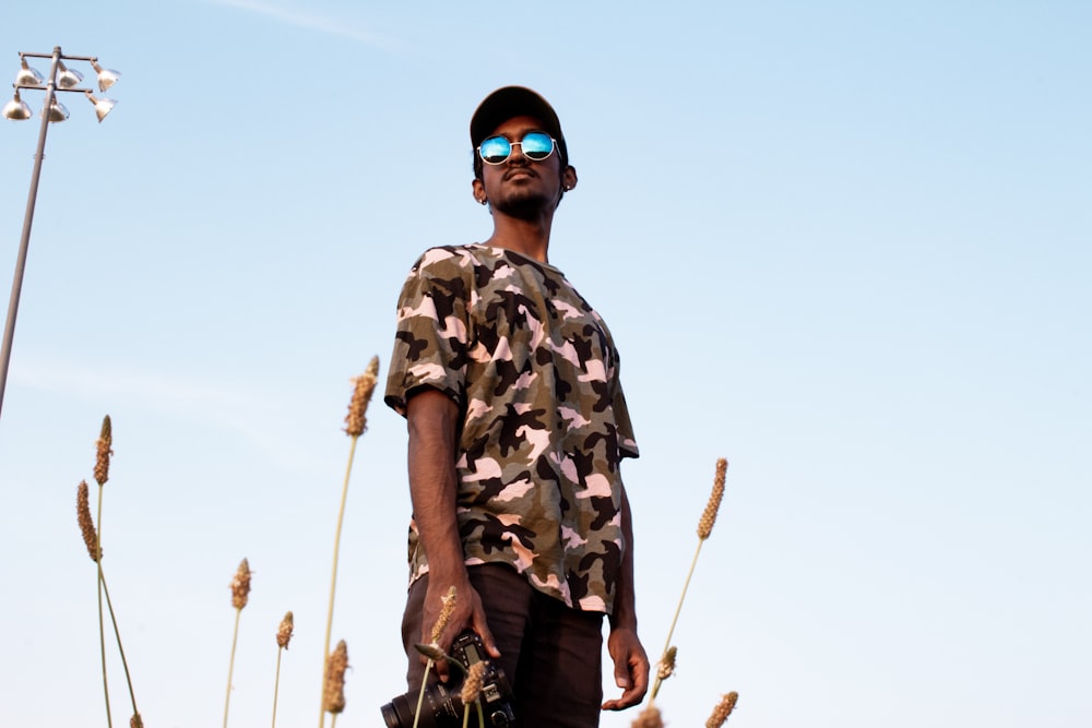 man in brown and black camouflage and black bottoms outfit