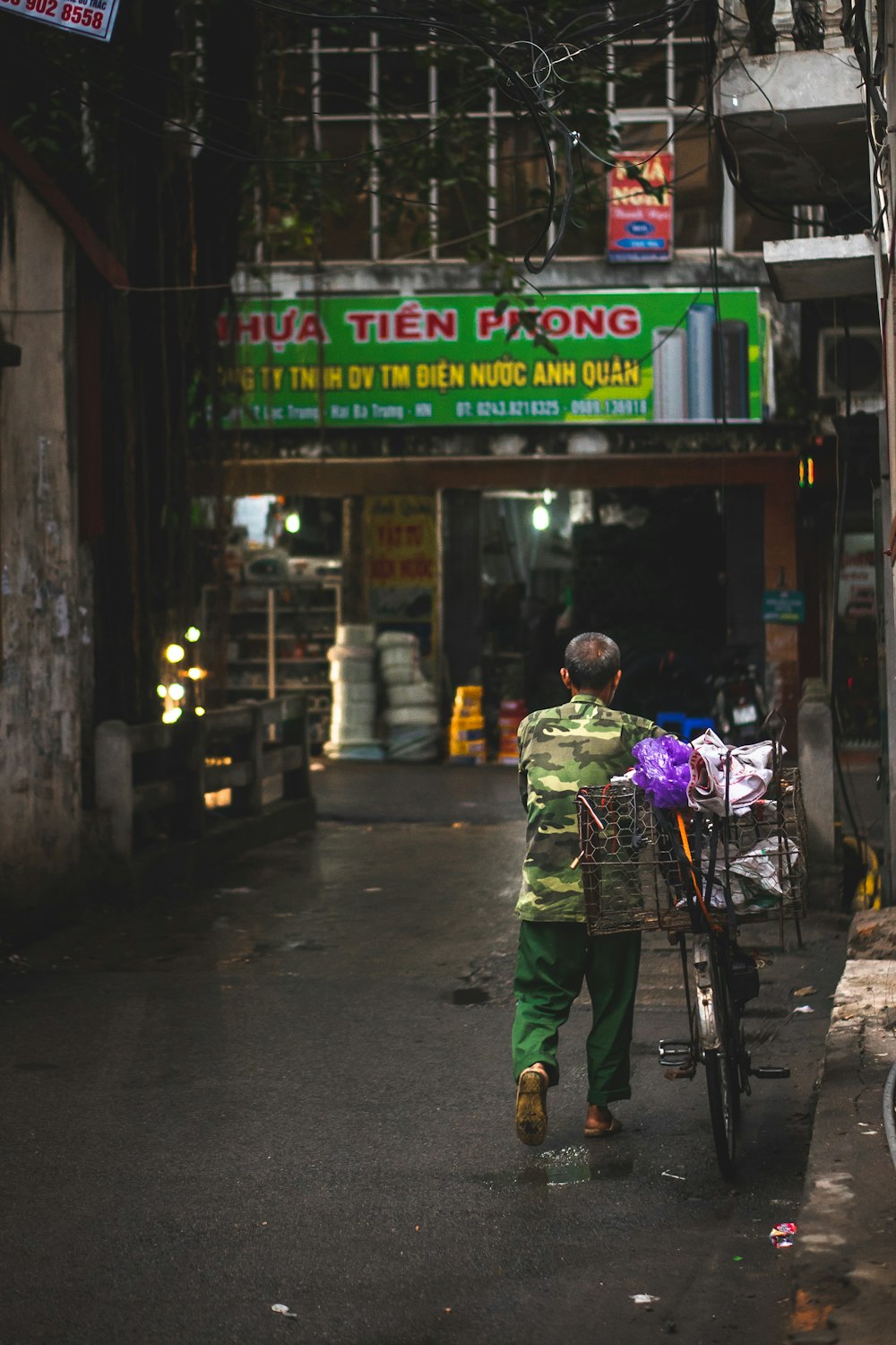 homme portant un costume de camouflage vert et beige tenant un vélo