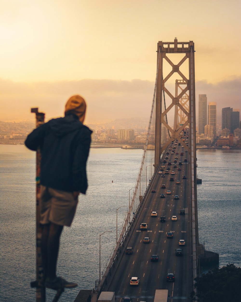 man standing looking bridge