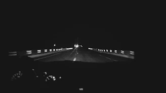 Dashboard camera with night vision feature recording on a dark highway at night.