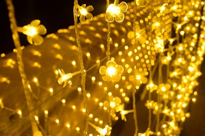 Delicate anime-inspired phone charms hanging from a string of fairy lights.