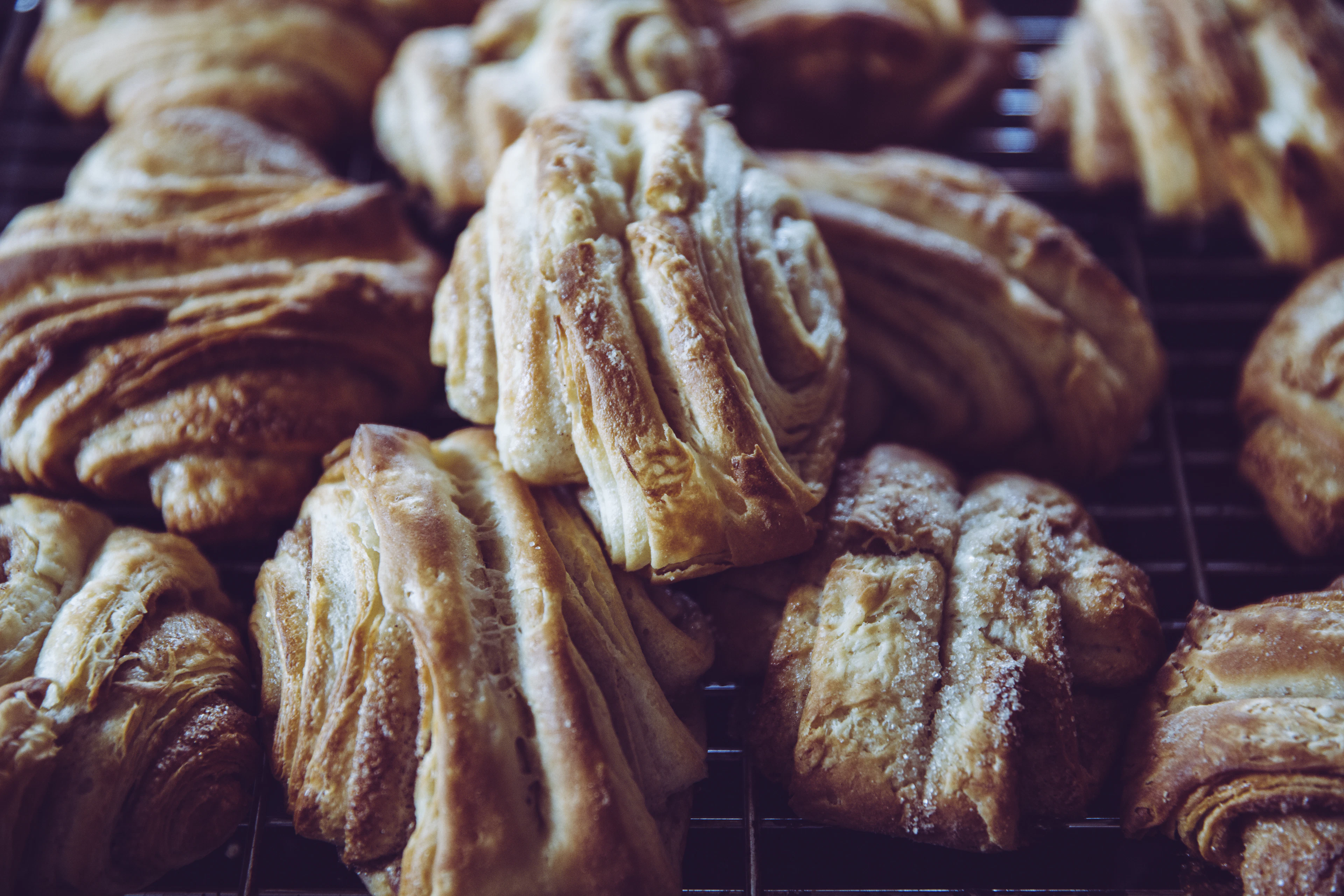 Freshly baked flaky cinnamon-sugar pastries cooling on a wire rack, the kind northern German bakeries sell at breakfast