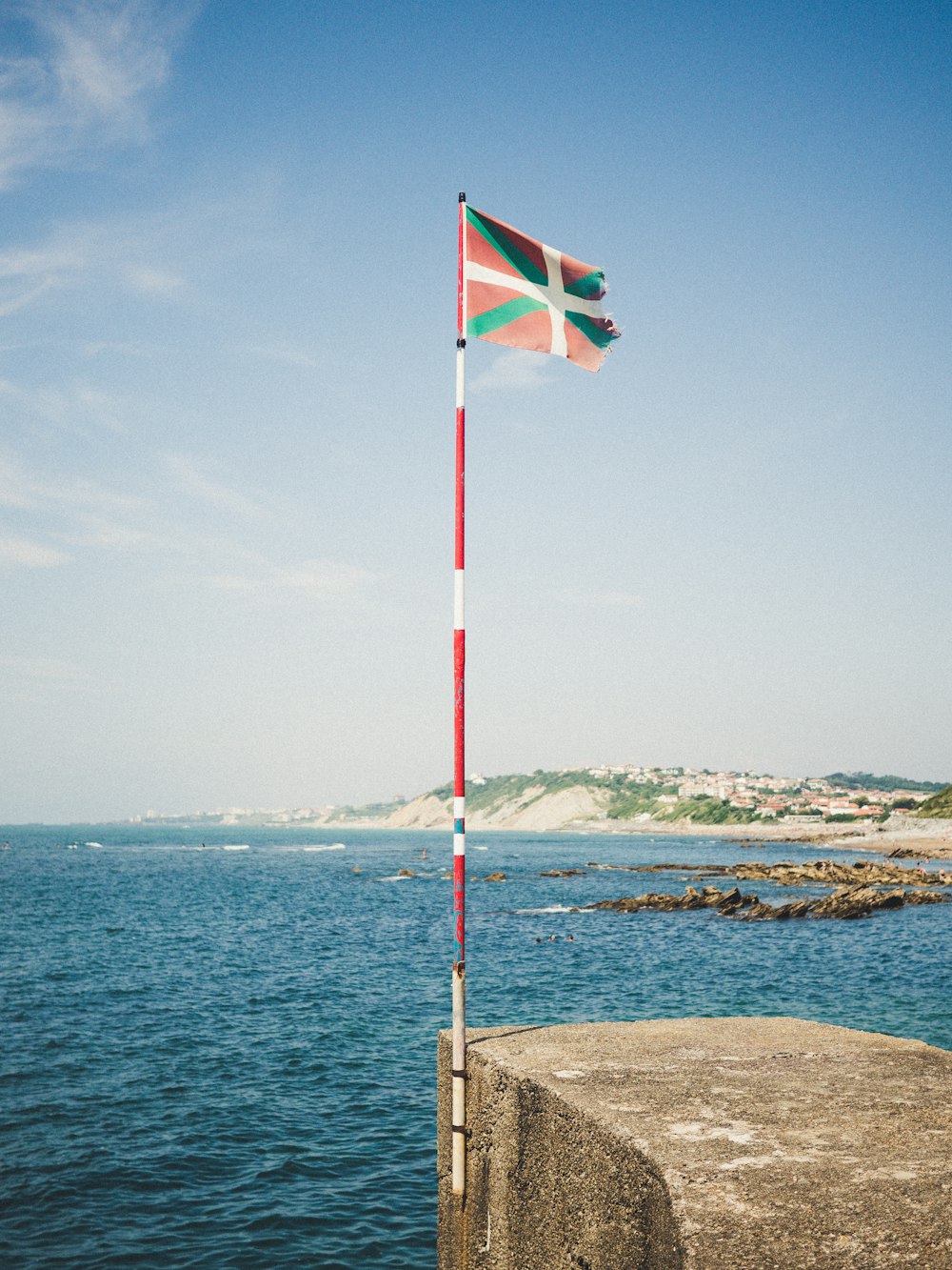 waving flag surrunded by body of water