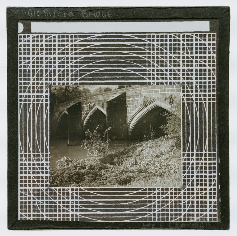 a black and white photo of a bridge over a river