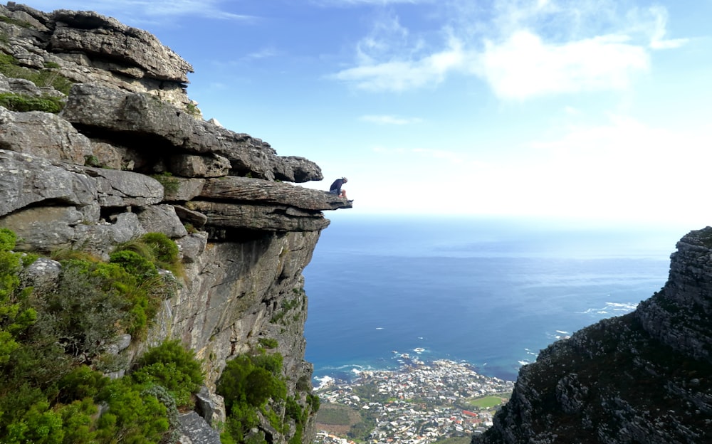 person sitting on mountain under cloudy sky