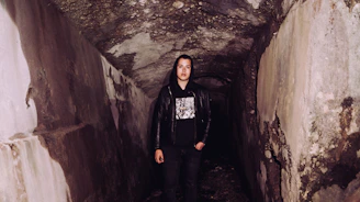 Stylish noirmine jacket draped over mining equipment with a backdrop of underground tunnels.