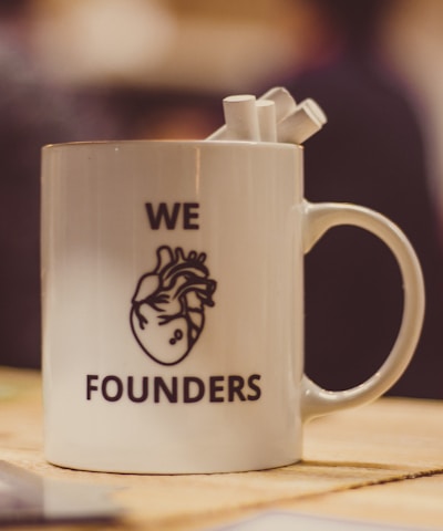 selective focus photo of we Founders heart-printed ceramic mug