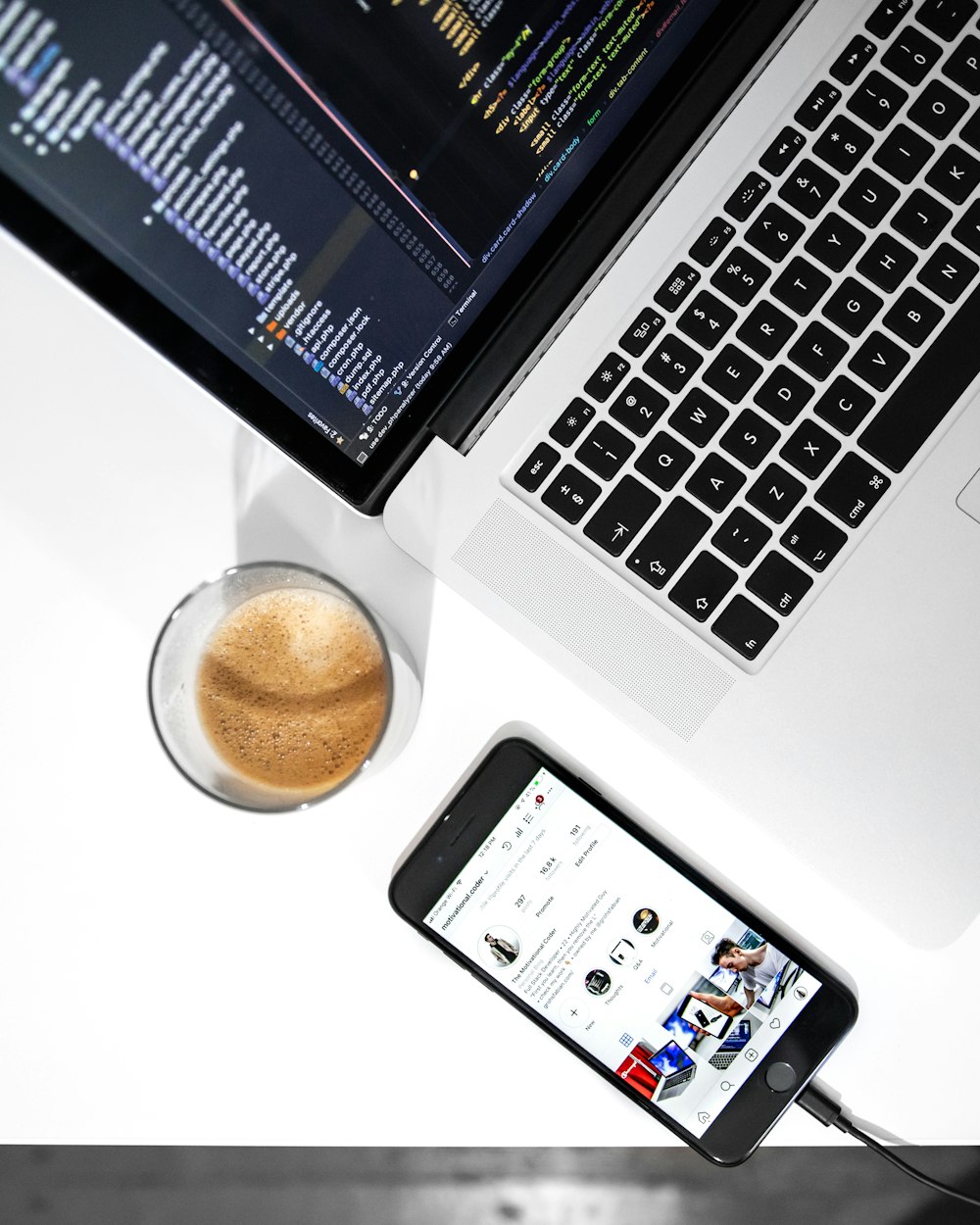 MacBook Pro in der Nähe von Space Grau iPhone 6 auf weißem Holztisch