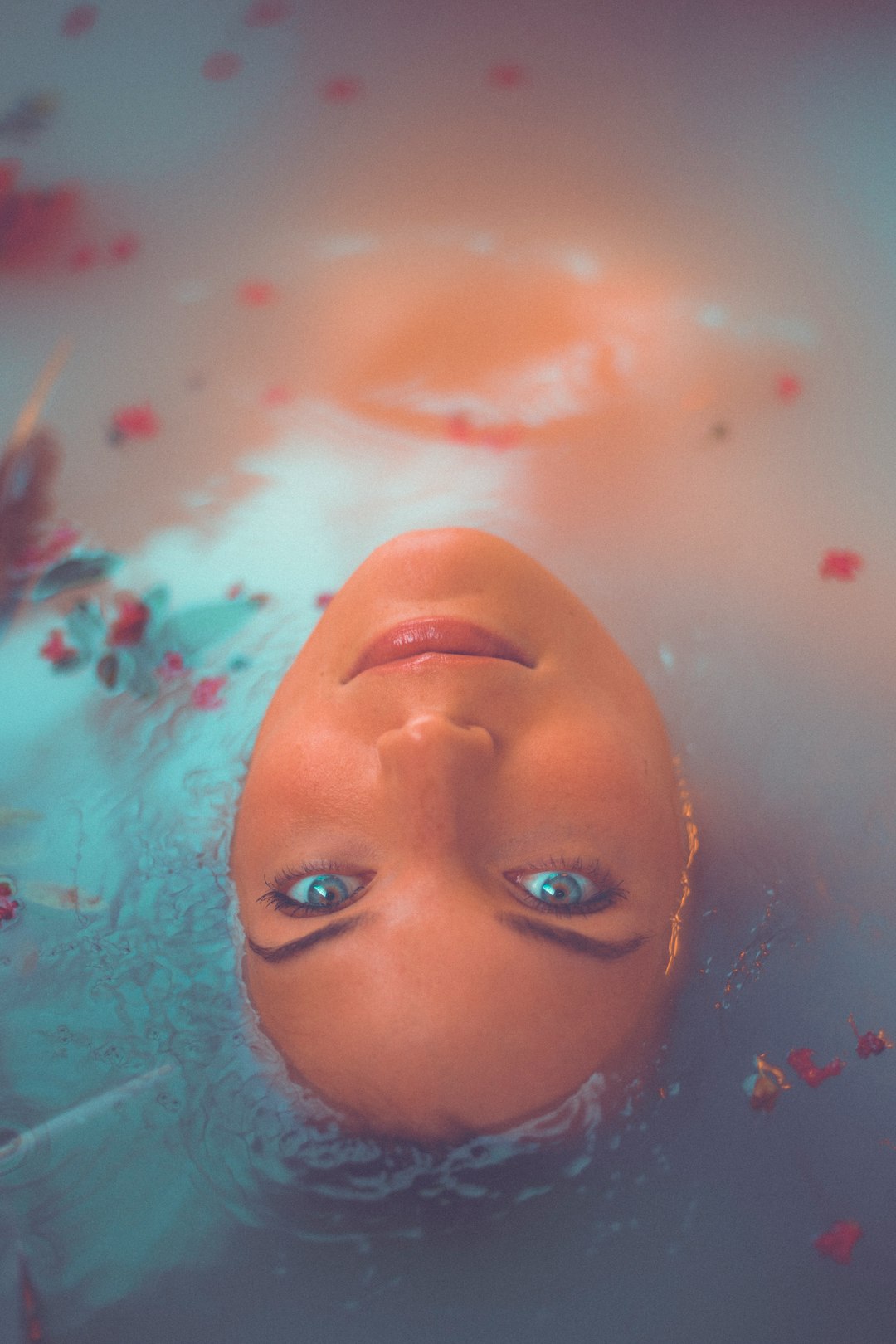 woman bathing on water with red flower petals