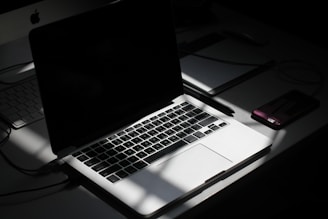 black and silver laptop computer beside smartphone