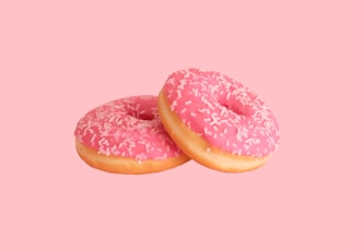 two strawberry doughnuts with sprinkles