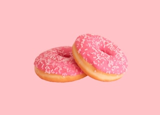two strawberry doughnuts with sprinkles