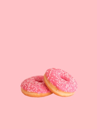 two strawberry doughnuts with sprinkles