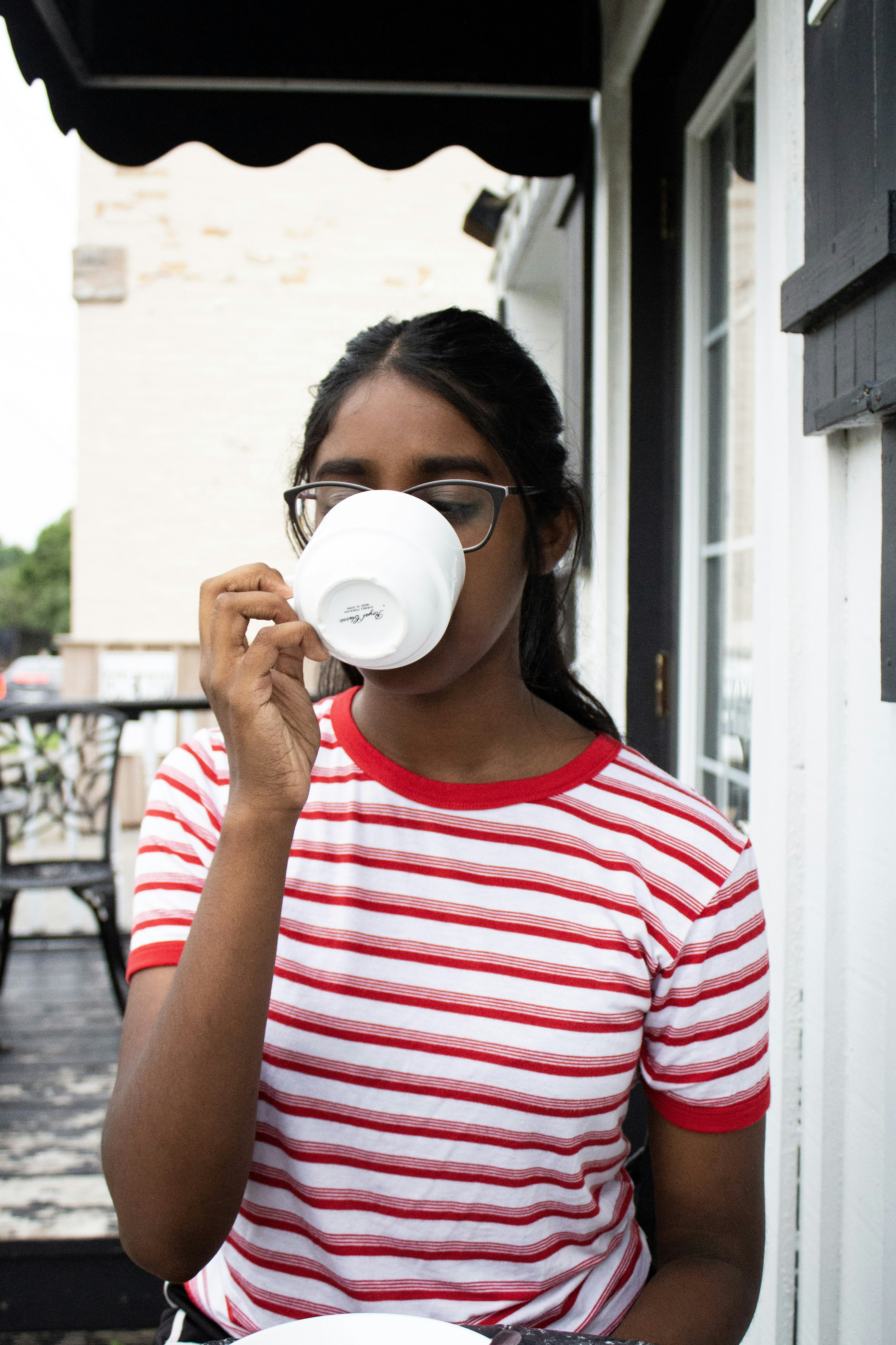 woman drinking coffee outside house