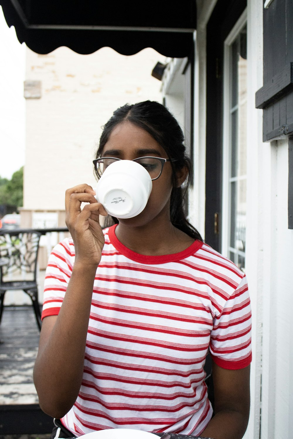woman drinking coffee outside house