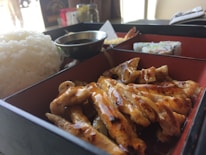 Close-up of a steaming hot Japanese-inspired bento box with fresh ingredients.