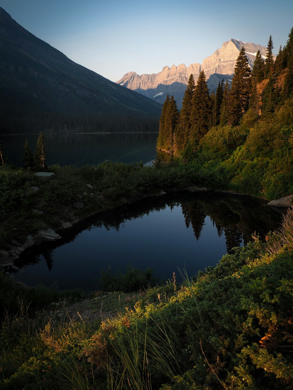 aerial view of body of water beside mountain