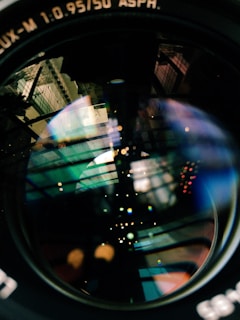Close-up shot of a camera lens reflecting colorful lights.