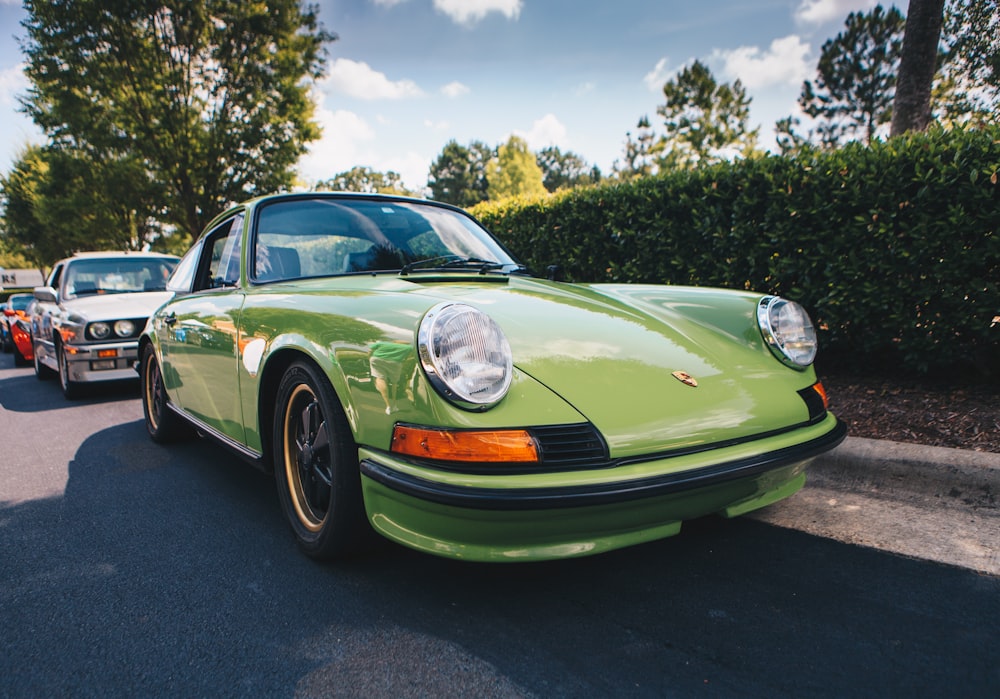 coupé sportiva verde parcheggiata accanto alla pianta