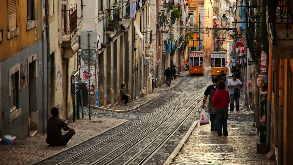 people walking on street near houses at daytime