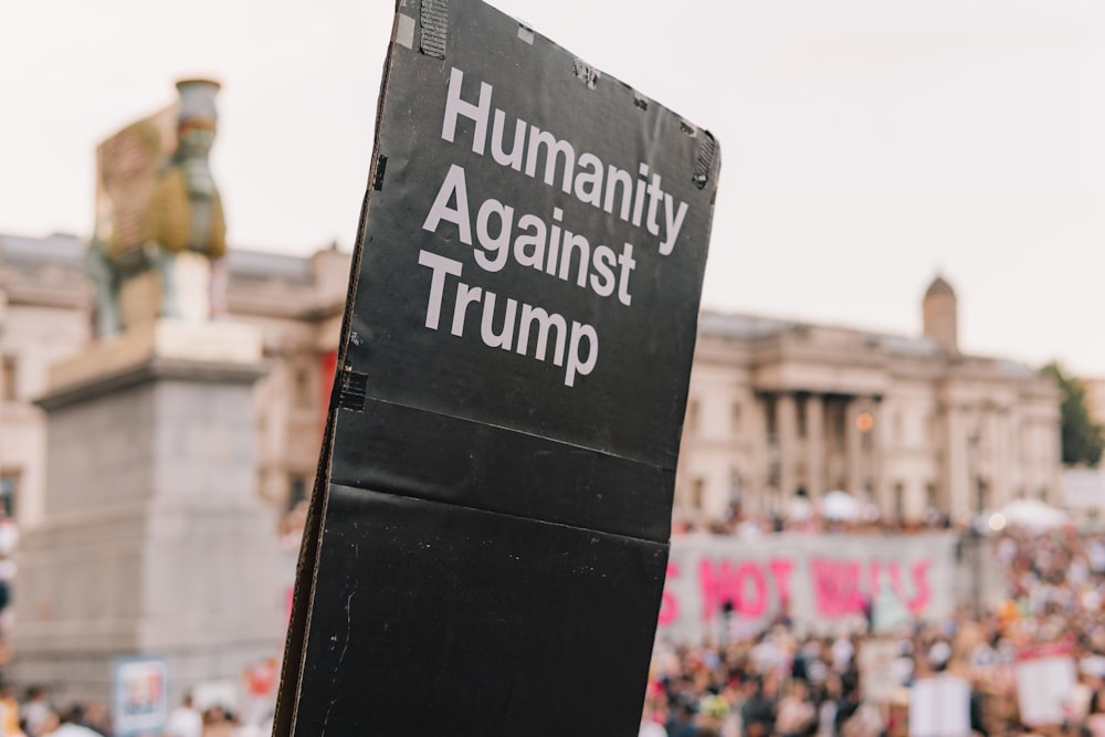 Umanità contro la segnaletica di Trump vicino agli edifici