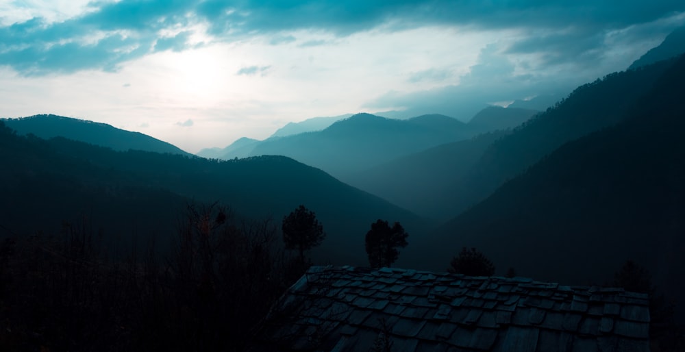 a view of a mountain range with a house in the foreground