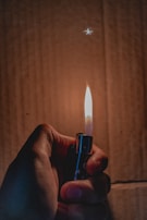 An MK lighter being held in a hand, showing its compact size and ergonomic shape.