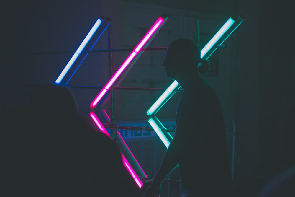 silhouette of man near neon lights