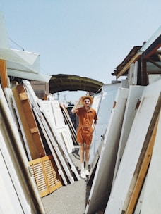 person standing beside white wooden panels