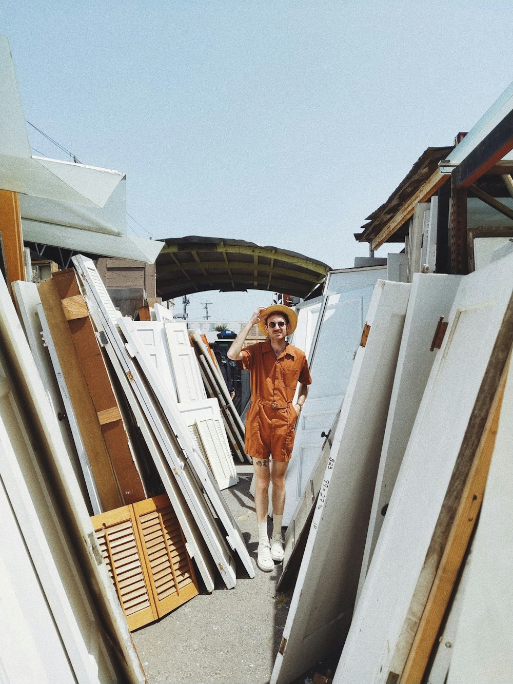 person standing beside white wooden panels