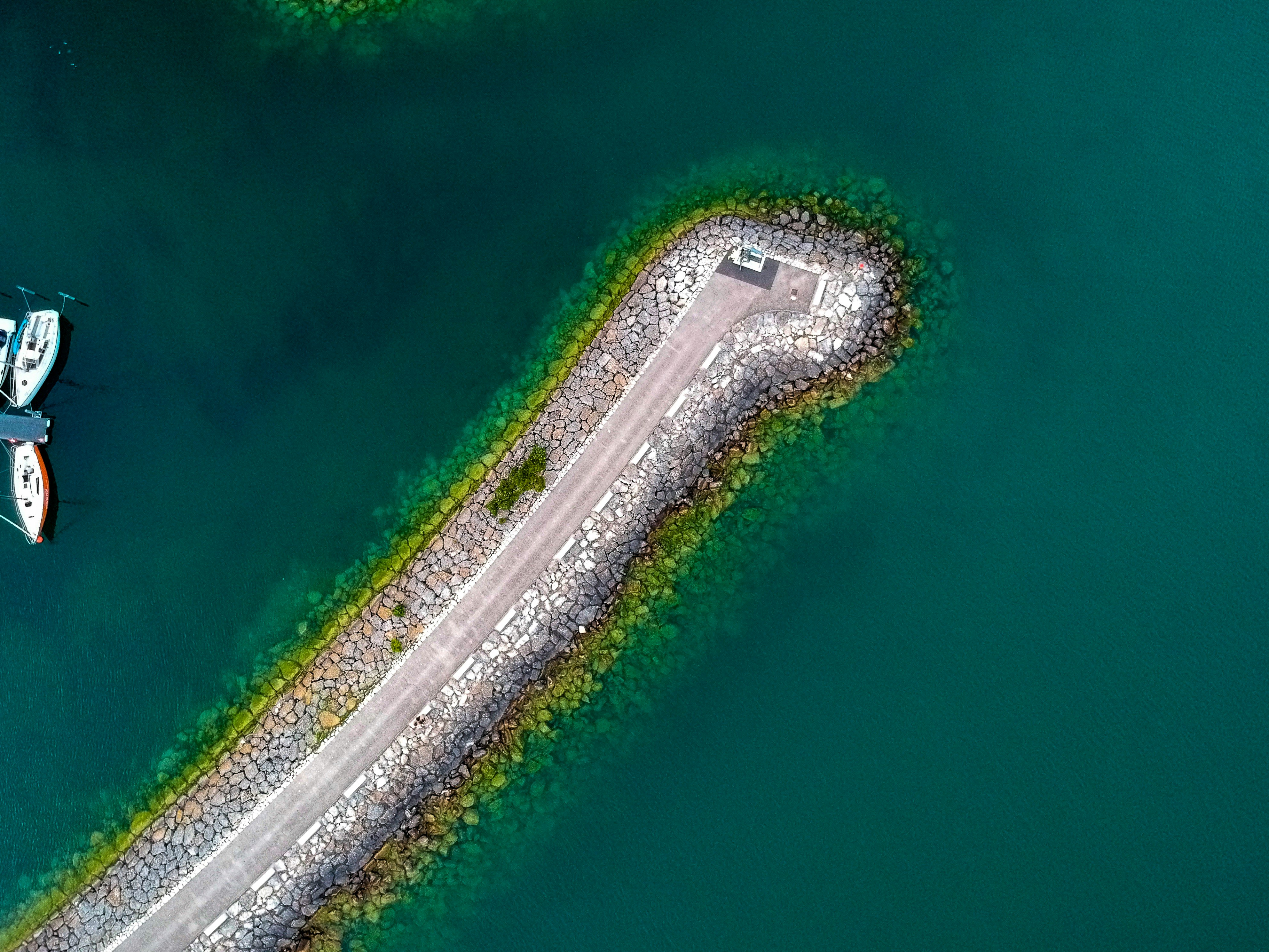 bird\s eye view of concrete road surrounded by body of water