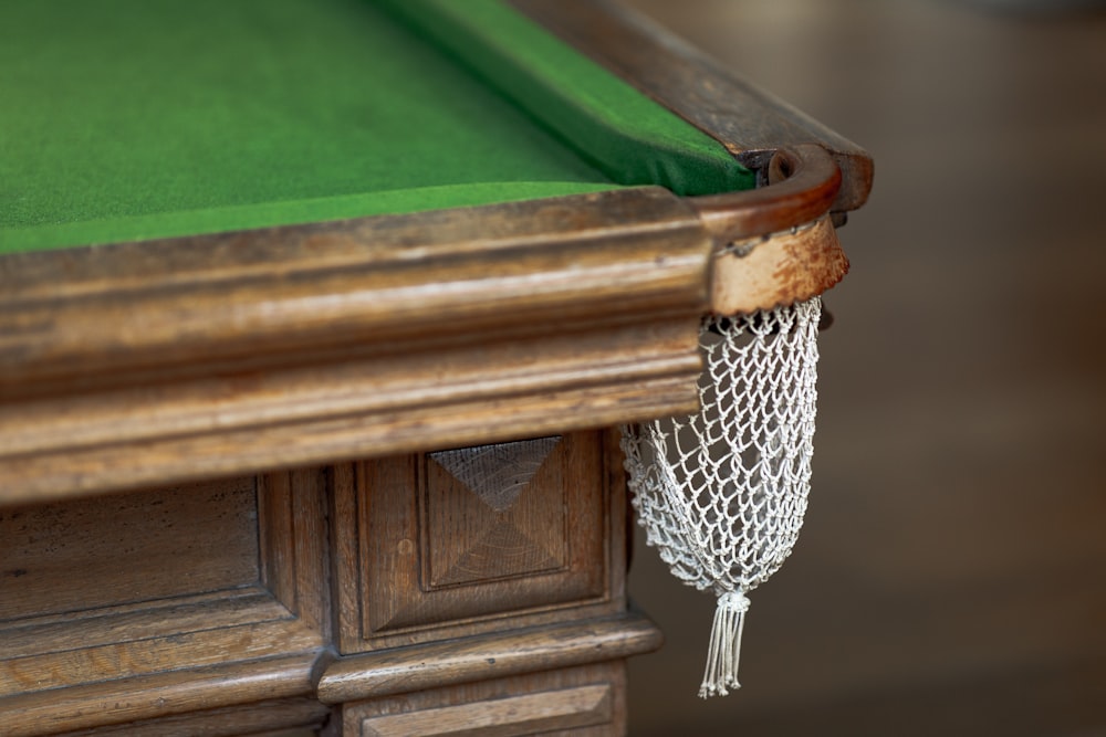 Photographie en gros plan de la poche d’angle de table de billard vert et brun