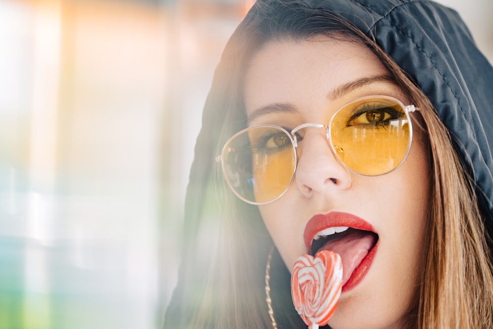 woman licking heart lollipop