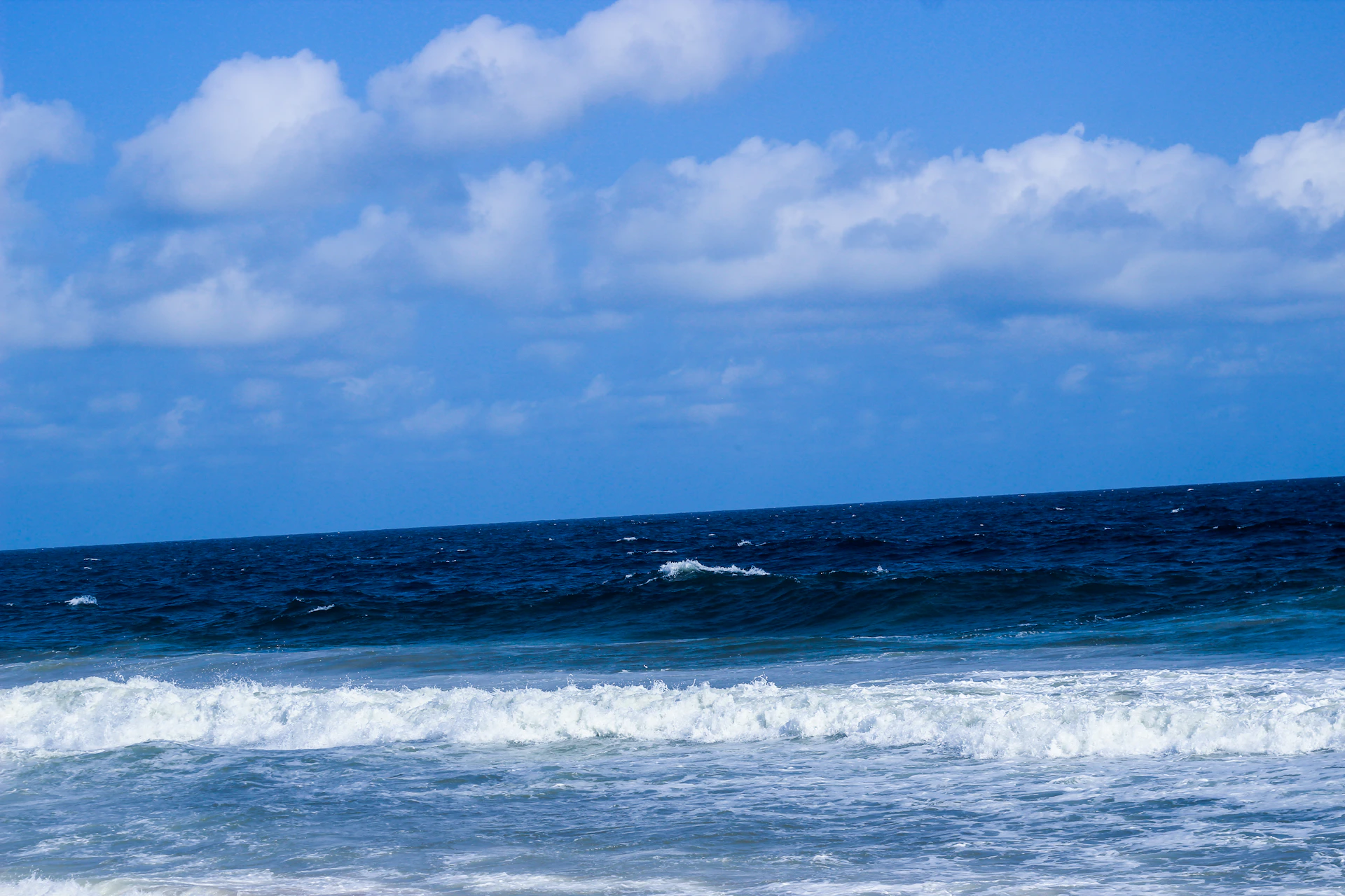 woman wearing yellow long-sleeved dress under white clouds and blue sky during daytime