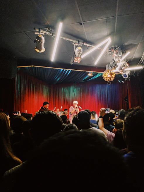 An atmospheric shot of a live music performance in a dimly lit venue with gold accents.