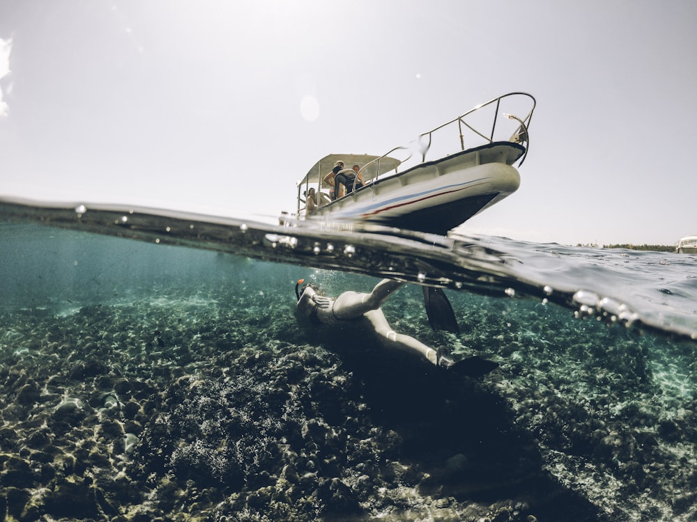 person riding on bow rider in body of water