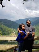 Couple enjoying a luxury stay balcony overlooking misty mountain valleys.