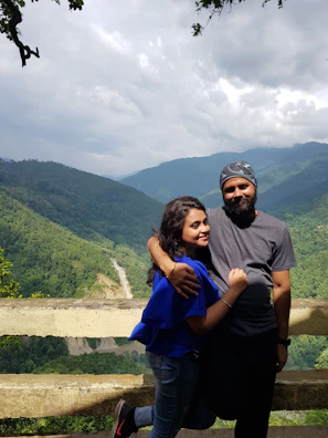 Couple enjoying a luxury stay balcony overlooking misty mountain valleys.