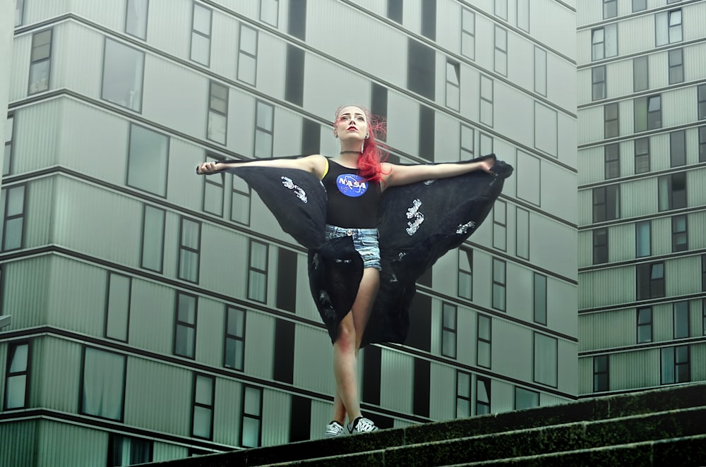 femme debout près d’un bâtiment pendant la journée