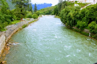 A serene river flowing through a lush green landscape with engineered water channels.