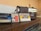 Three vintage audio cassette tapes in various colors are placed on a wooden surface next to a retro-style radio. The cassettes and radio create a nostalgic ambience.