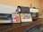 Three vintage audio cassette tapes in various colors are placed on a wooden surface next to a retro-style radio. The cassettes and radio create a nostalgic ambience.